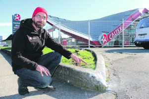 Caltex Solway owner Kevan Dudson points to the curb which the fleeing driver hit before ploughing across the grass into a forecourt support beam. PHOTO/HAYLEY GASTMEIER