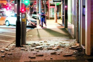Glass and rubble covers the footpath on Wakefield Street, Wellington. PHOTO/GETTY IMAGES