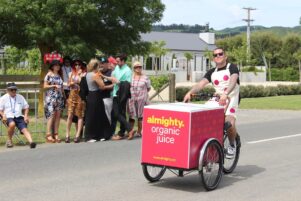 People wait at the Toast Martinborough bus stop as an Almighty juice mobile salesperson rides by. PHOTO/EMILY NORMAN