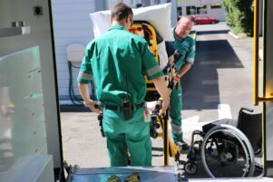 Andrew Gladding (left) and Al Bealing prepare to load the stretcher and patient into the ambulance. PHOTO/HAYLEY GASTMEIER